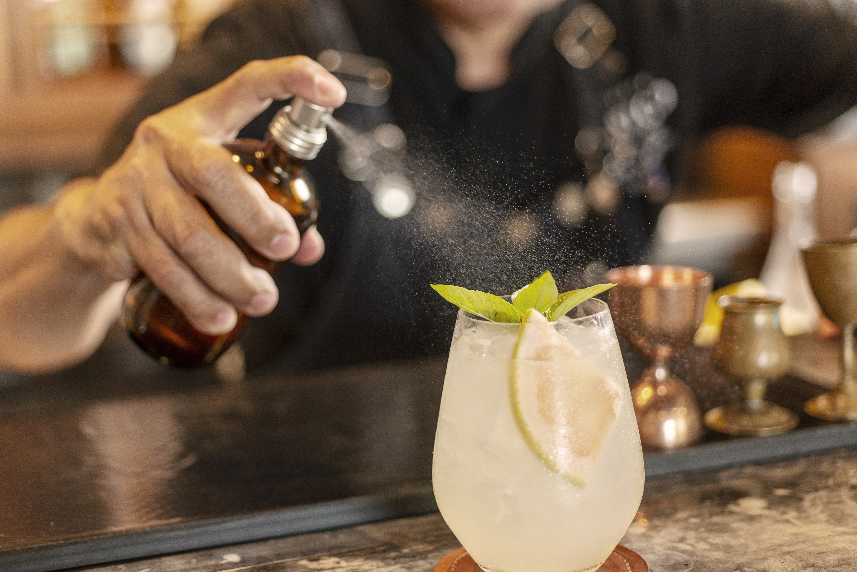 una persona rociando una bebida en un vaso