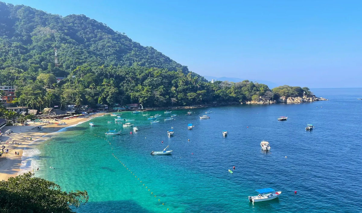 Riviera Nayarit coastline with green mountains, turquoise water, and boats offshore